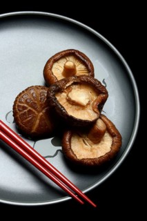 Dried and soaked shiitake mushrooms on a plate with chopsticks