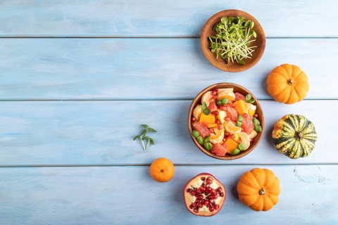 Vegetarian fruit salad of pumpkin, tangerine, pomegranate, grapefruit, sunflower microgreen sprouts