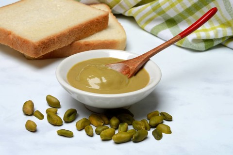 Pistachio cream in small bowls and slices of bread, pistachio