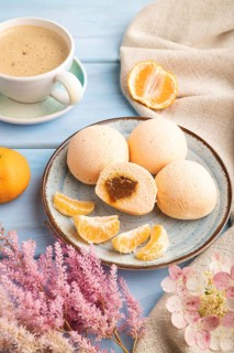 Japanese rice sweet buns mochi filled with tangerine jam and cup of coffee on a blue wooden