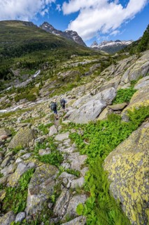 Mountaineers on a hiking trail in front of a picturesque mountain landscape, rocky mountain peaks