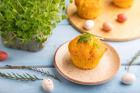 Homemade cakes with chocolate eggs and mizuna cabbage microgreen on a blue wooden background. side
