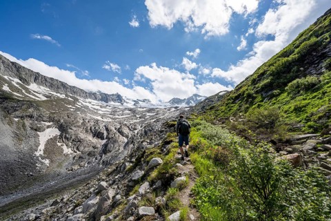 Mountaineer on hiking trail, mountain landscape with rocky mountains and snow, Berliner Hoehenweg,