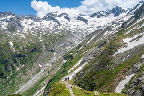 Mountaineer on hiking trail in picturesque mountain landscape, in the background mountain peak