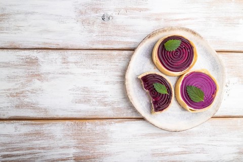 Sweet tartlets with jelly and milk cream on a white wooden background. top view, flat lay, copy