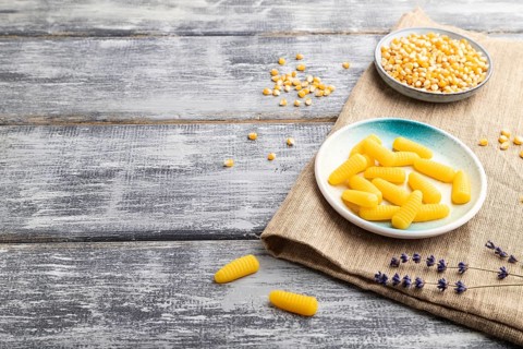 Jelly corn candies on gray wooden background and linen textile. copy space, side view
