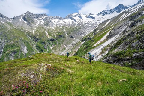 Mountaineer on hiking trail in picturesque mountain landscape, in the background mountain peak