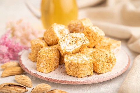 Traditional turkish delight (rahat lokum) with glass of green tea on a gray concrete background and