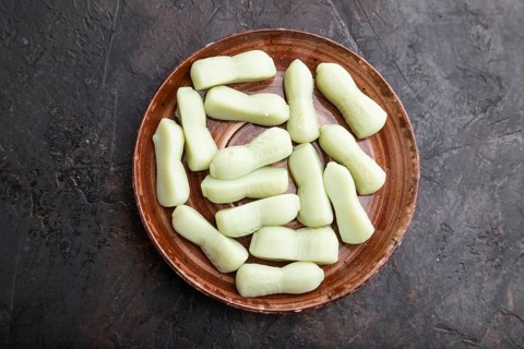 Jelly celery candies on black concrete background, top view, flat lay, close up