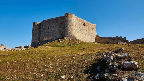 Medieval fortress in a meadow, with a light blue sky in the background, Chlemoutsi, High Medieval