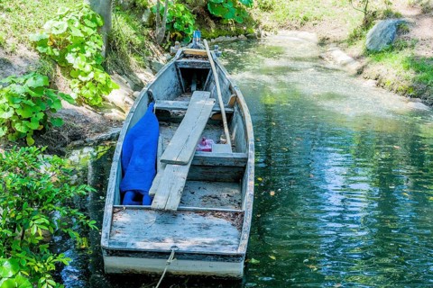 Wooden row boat at shore of lake in Japanese Shukkeien Gardens in Hiroshima, Japan, Asia