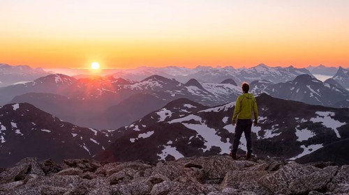 Mountaineer enjoying the view, mountain panorama at the summit of Skala at sunset, sun setting
