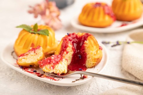 Semolina cheesecake with strawberry jam, lavender, cup of coffee on gray concrete background and