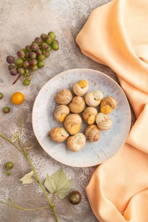 Grape (Burgundy) snails with butter and cheese on brown concrete background and orange textile. Top