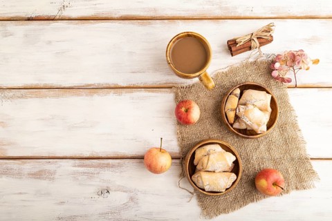 Homemade sweet cookie with apple jam and cup of coffee on white wooden background and linen textile