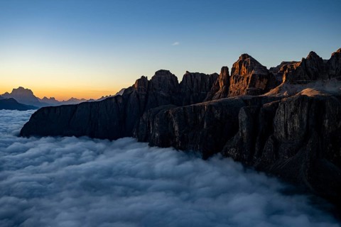 Sunrise over a sea of fog with the peaks of the Sella massif in the background, Corvara, Dolomites,