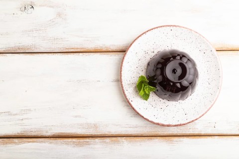 Black currant and grapes jelly on white wooden background. top view, flat lay, copy space