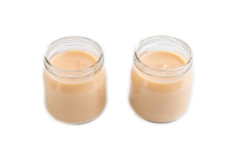 Baby puree with fruits mix, apple, banana infant formula in glass jar isolated on white background.
