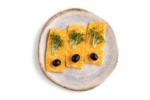 Marble cheese with olives and watercress microgreen isolated on white background. top view, flat