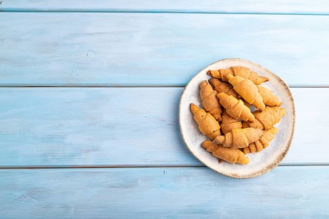 Homemade bagel roll on a blue wooden background. top view, flat lay, copy space