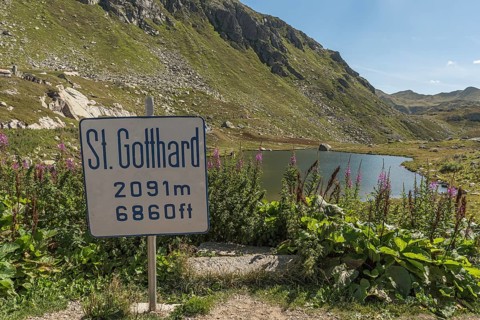 Gotthard Pass, mountain lake and sign with altitude information at the top of the pass, Canton