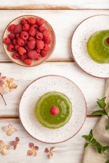 Mint and raspberry green jelly on white wooden background. top view, flat lay, close up