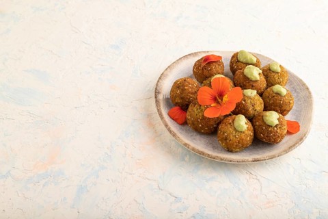 Falafel with guacamole on white concrete background. Side view, copy space