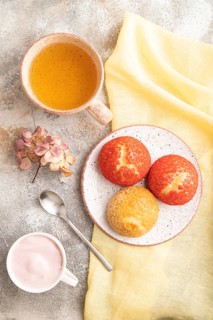 Traditional french custard dessert shu cake and cup of green tea on brown concrete background and