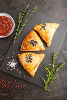 Homemade asian pastry samosa on black concrete background. top view, flat lay, close up