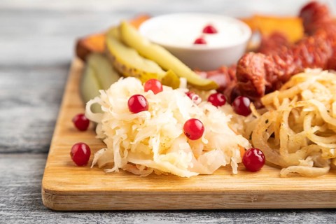 Set of snacks: sausages, toast, sauerkraut, marinated onion and cucumber, baked potato on a cutting