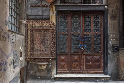 18th century Madonna and Child, protected by a wrought-iron grille, on the right an old barred