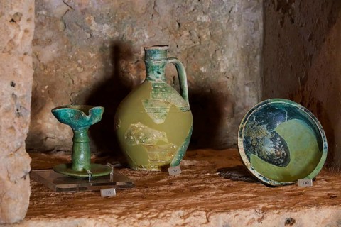 Ancient artefacts, including a vase and a bowl, displayed on a stone plinth, Museum, Chlemoutsi,