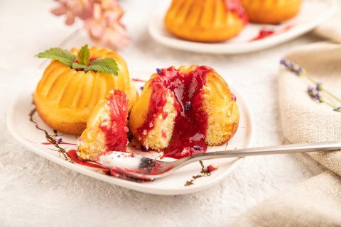Semolina cheesecake with strawberry jam, lavender, cup of coffee on gray concrete background and