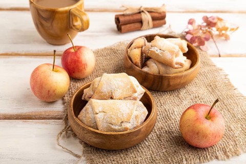 Homemade sweet cookie with apple jam and cup of coffee on white wooden background and linen textile