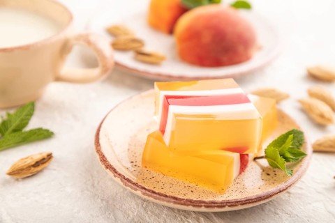 Almond milk and peach jelly on gray concrete background. side view, close up, selective focus