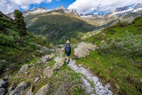 Mountaineers on a hiking trail in front of a picturesque mountain landscape, rocky mountain peaks