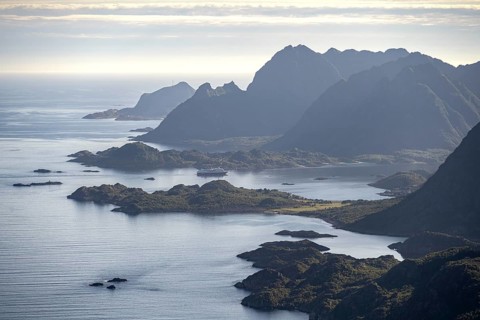 View of the coast in Ulvagsundet fjord and mountains in the evening light, Hurtigruten cruise ship