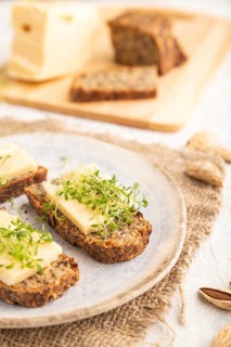 Grain bread sandwiches with cheese and watercress microgreen on gray concrete background and linen