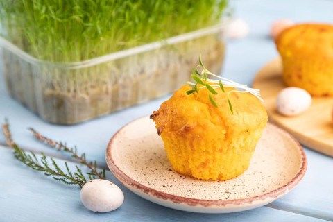 Homemade cakes with chocolate eggs and carrot microgreen on a blue wooden background. side view,