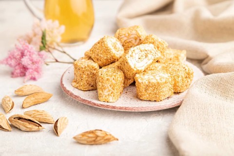 Traditional turkish delight (rahat lokum) with glass of green tea on a gray concrete background and