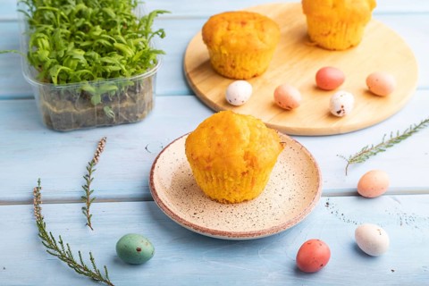 Homemade cakes with chocolate eggs and chrysanthemum microgreen on a blue wooden background. side