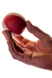 Hand with a juggling ball in front of a white background, studio shot, Germany, Europe