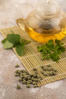 Green oolong tea with herbs in glass on brown concrete background. Healthy drink concept. Side