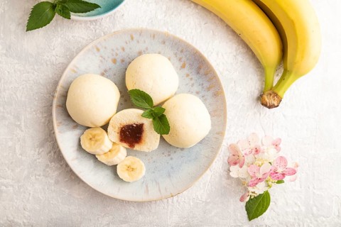 Japanese rice sweet buns mochi filled with jam and cup of coffee on a gray concrete background. top