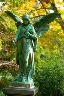 Female angel figure with rose, surrounded by autumnal colours, radiates peace, bronze with