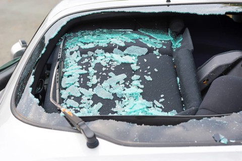 Accident car, sporty car with accident damage standing on a road, broken rear view window of a car
