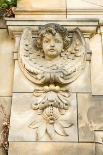 Historic stone angel figure, angel figure, angel with open gaze and detailed wings on a column,