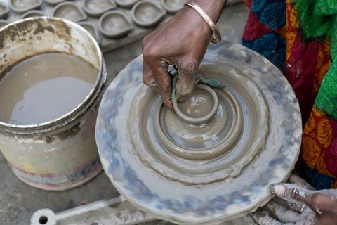 BARPETA, INDIA, NOVEMBER 7: A woman makes earthen lamps or Diyas at her residence ahead of the