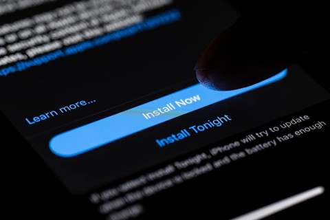 In this photo illustration a person installs updates of iOS 17.3 on an iPhone device on January 26,