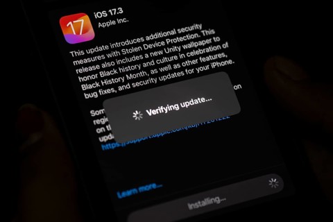 In this photo illustration a person installs updates of iOS 17.3 on an iPhone device on January 26,